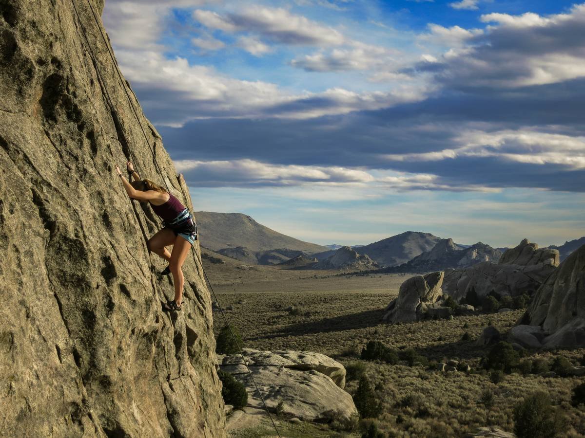 Infographic showing how fabric type, seam placement, and compression level impact climbing comfort and performance metrics like range of motion, chafing risk, and sweat wicking efficiency