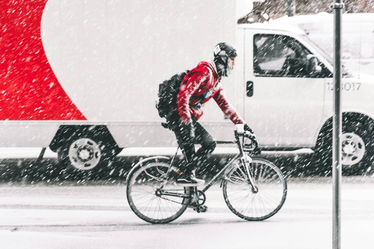 Infographic showing thermal zones on men's cycling tights: windproof panels on front thighs, fleece lining on rear/quads, breathable mesh behind knees