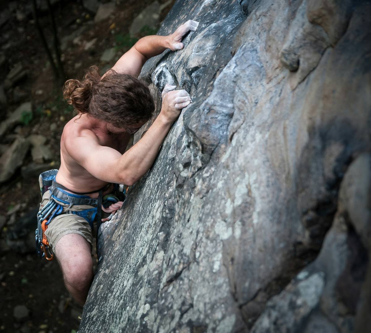 Woman practicing loose free climbing in breathable, mobility-focused tights on outdoor rock face