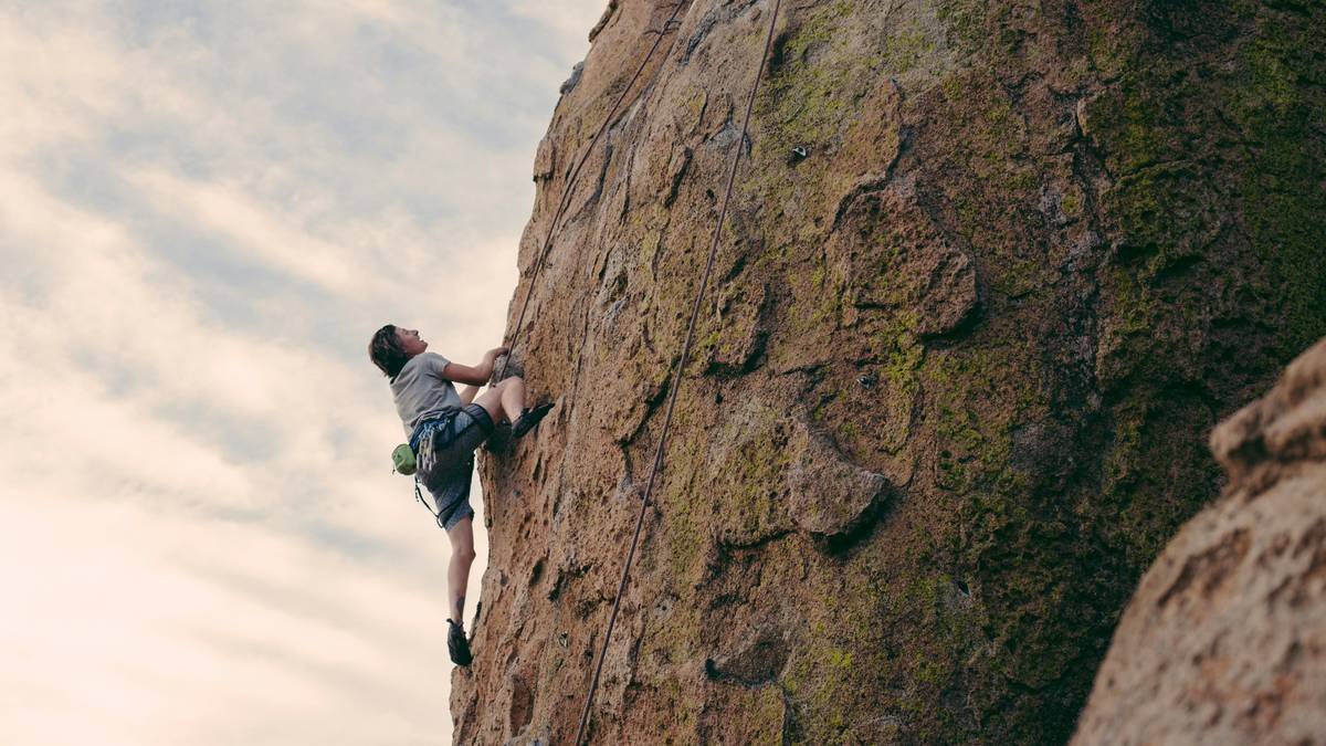 Climber demonstrating full range of motion in climbing flex tights with articulated knee design